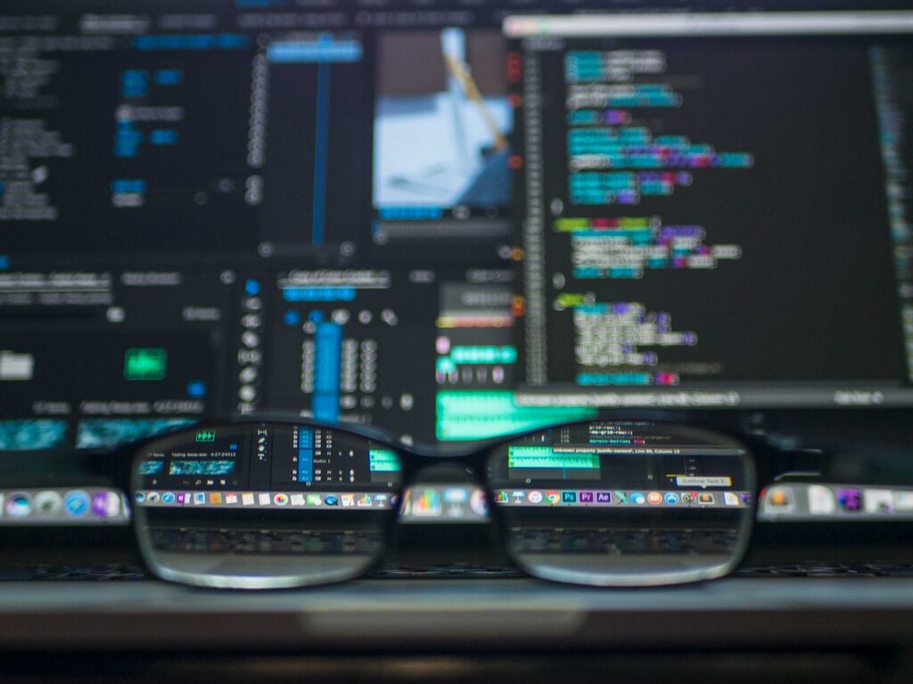 Monitorokon programkód, előtte egy szemüveg